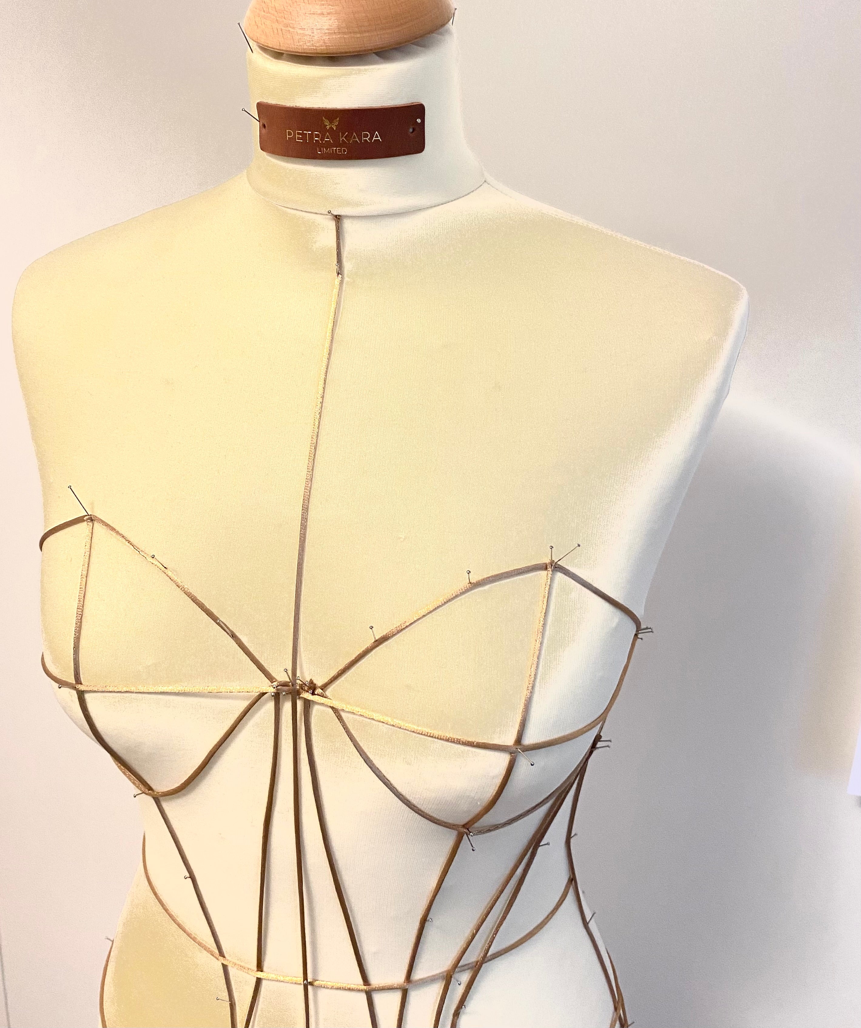 Petra Kara architectural corset dress with structured bodice and flowing skirt, displayed on a mannequin against a neutral backdrop.