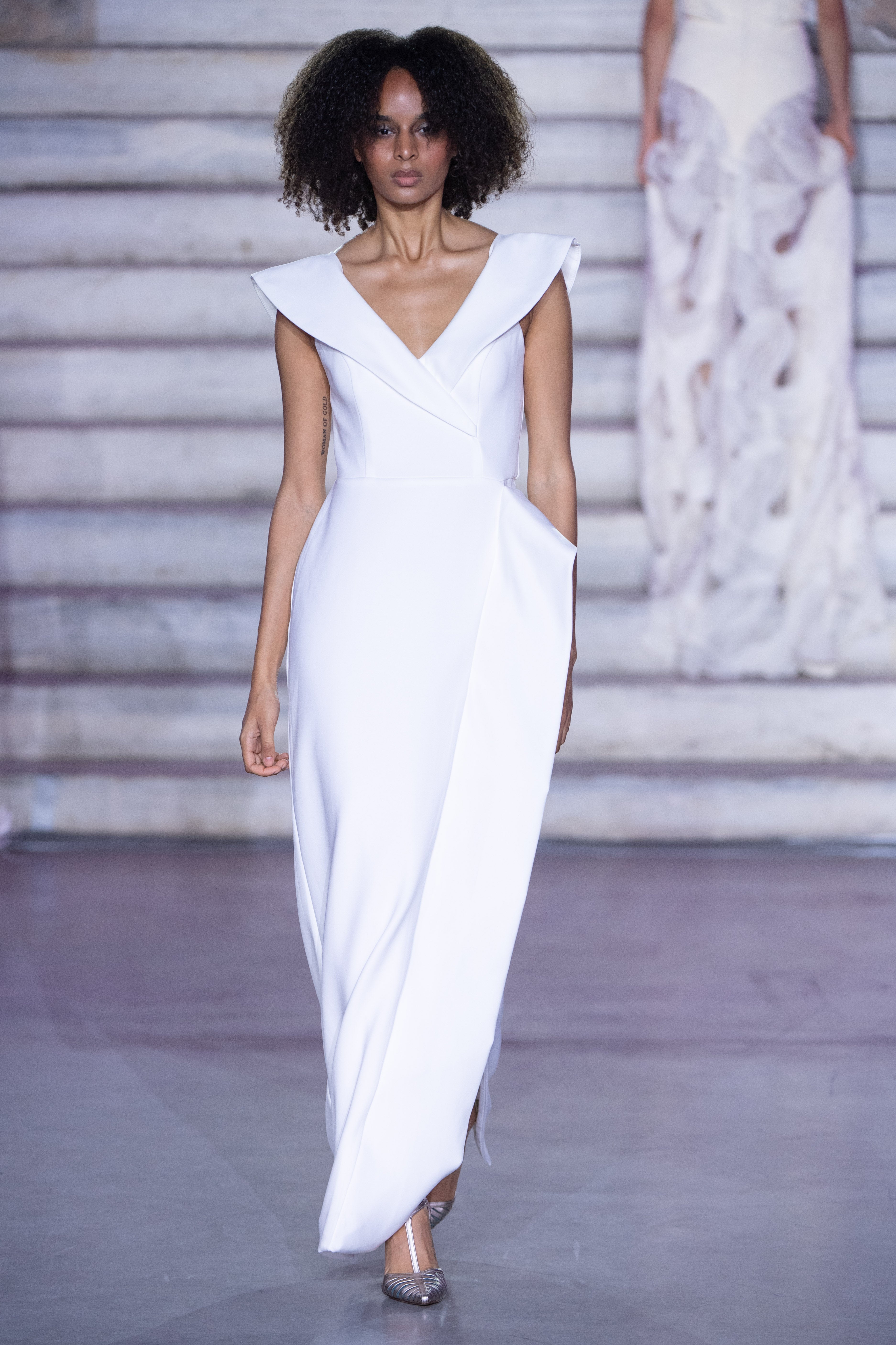 Petra Kara Aegean Architectural Dress displayed on a model, showcasing its intricate geometric design and flowing fabric.