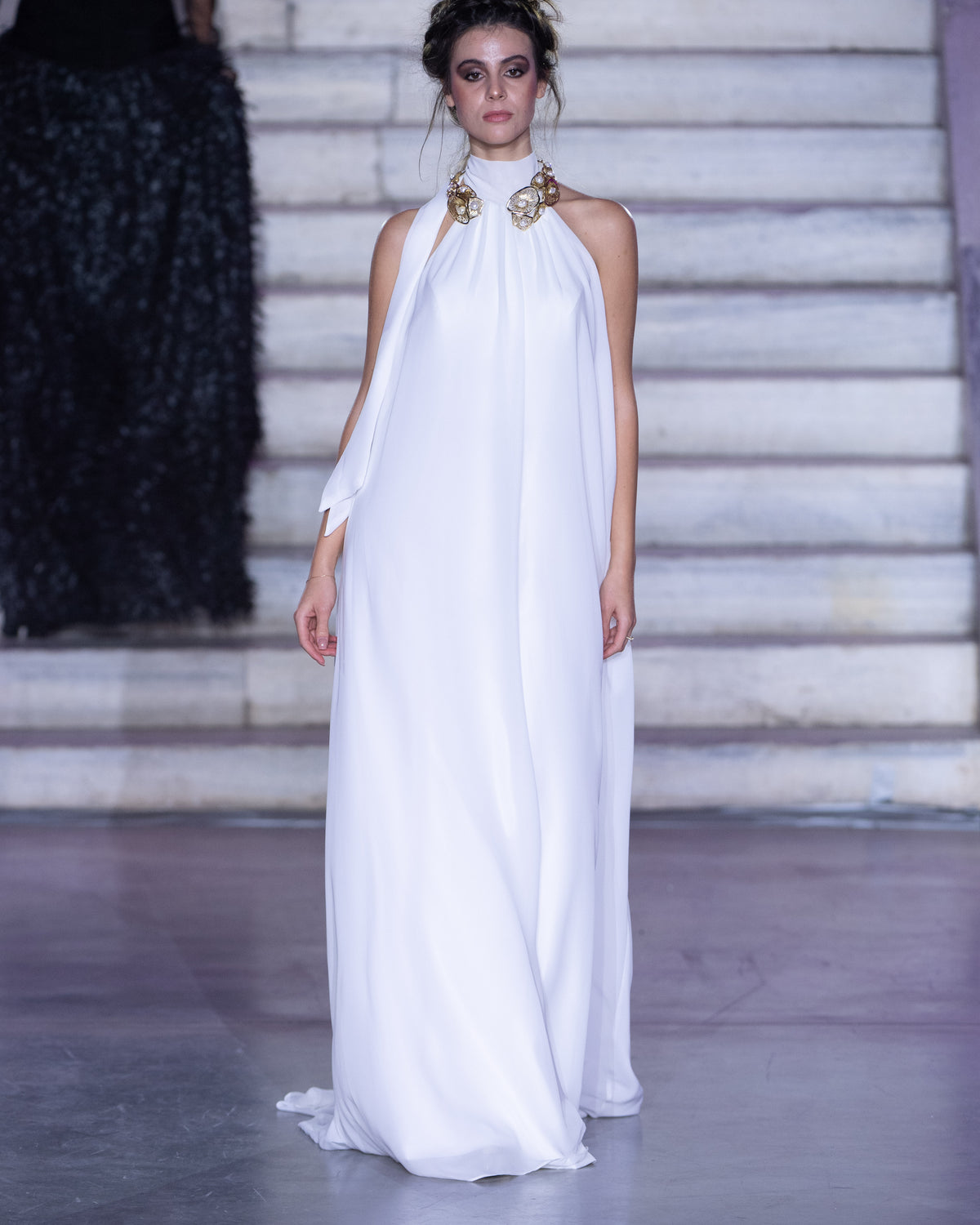 Petra Kara Ieria Effortless Gown displayed on a hanger with a flowing design and elegant details.