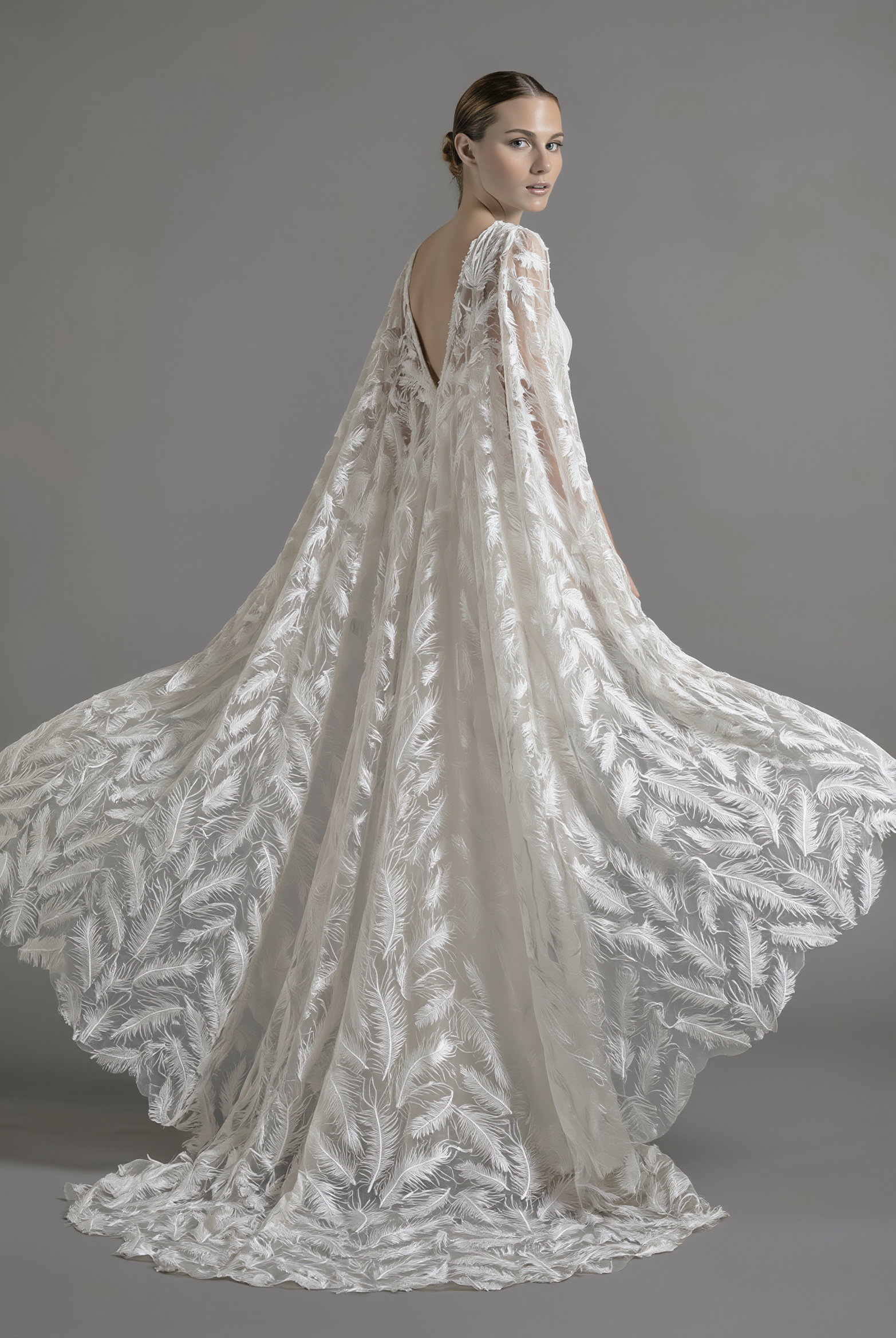 Elegant feather veil and cape by Atelier Calliste, showcasing delicate feather details and flowing fabric for a sophisticated look.