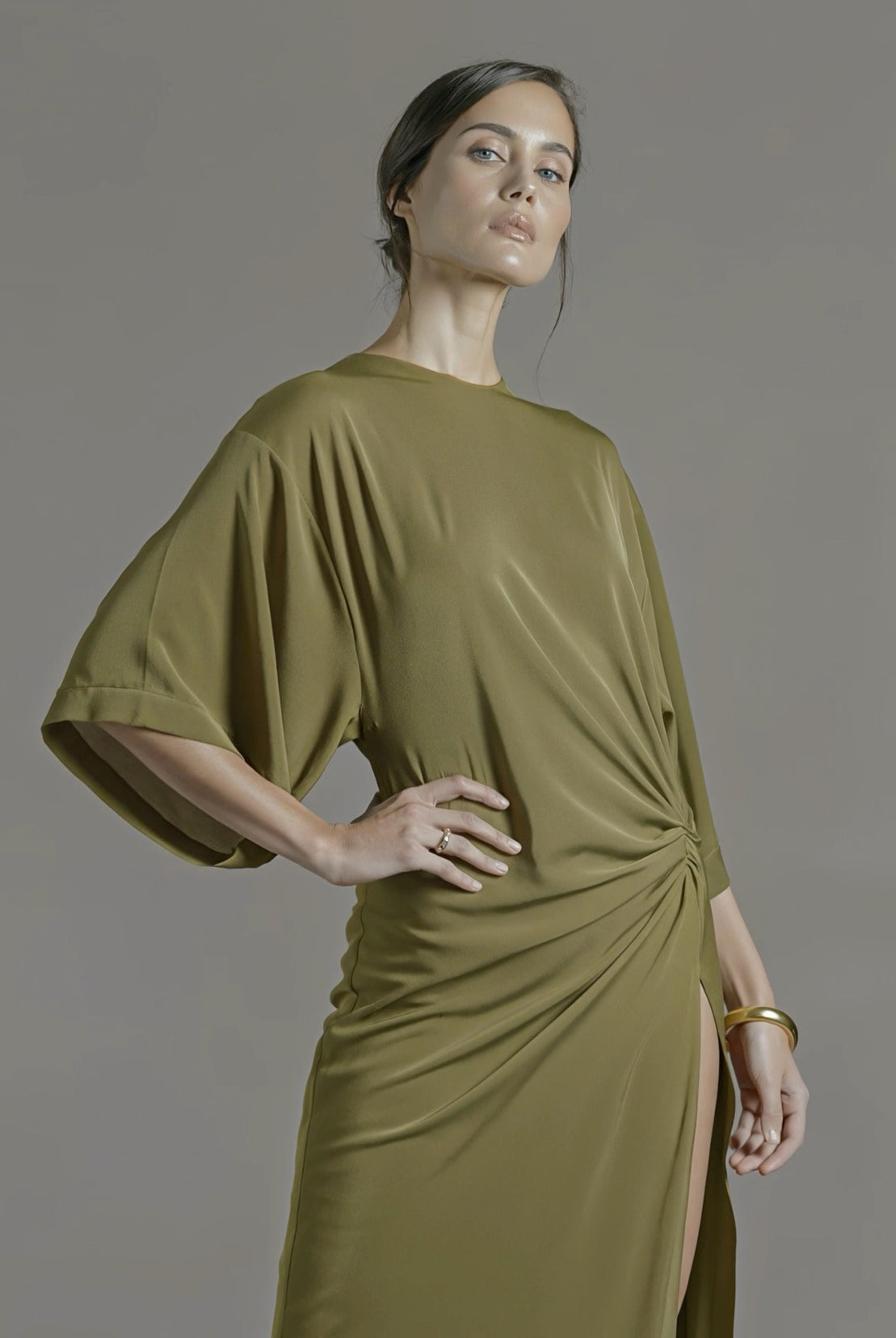 PETRA KARA Minimal Ekati Draped Dress displayed on a hanger with flowing fabric and elegant draping details.