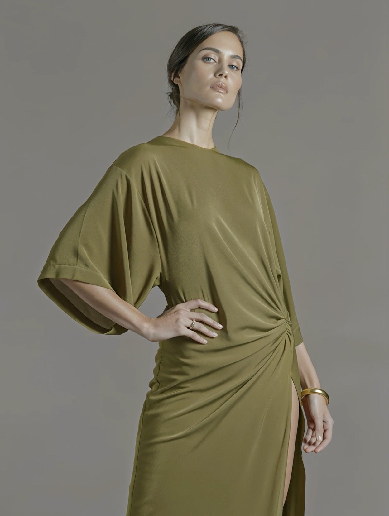 PETRA KARA Minimal Ekati Draped Dress displayed on a hanger with flowing fabric and elegant draping details.