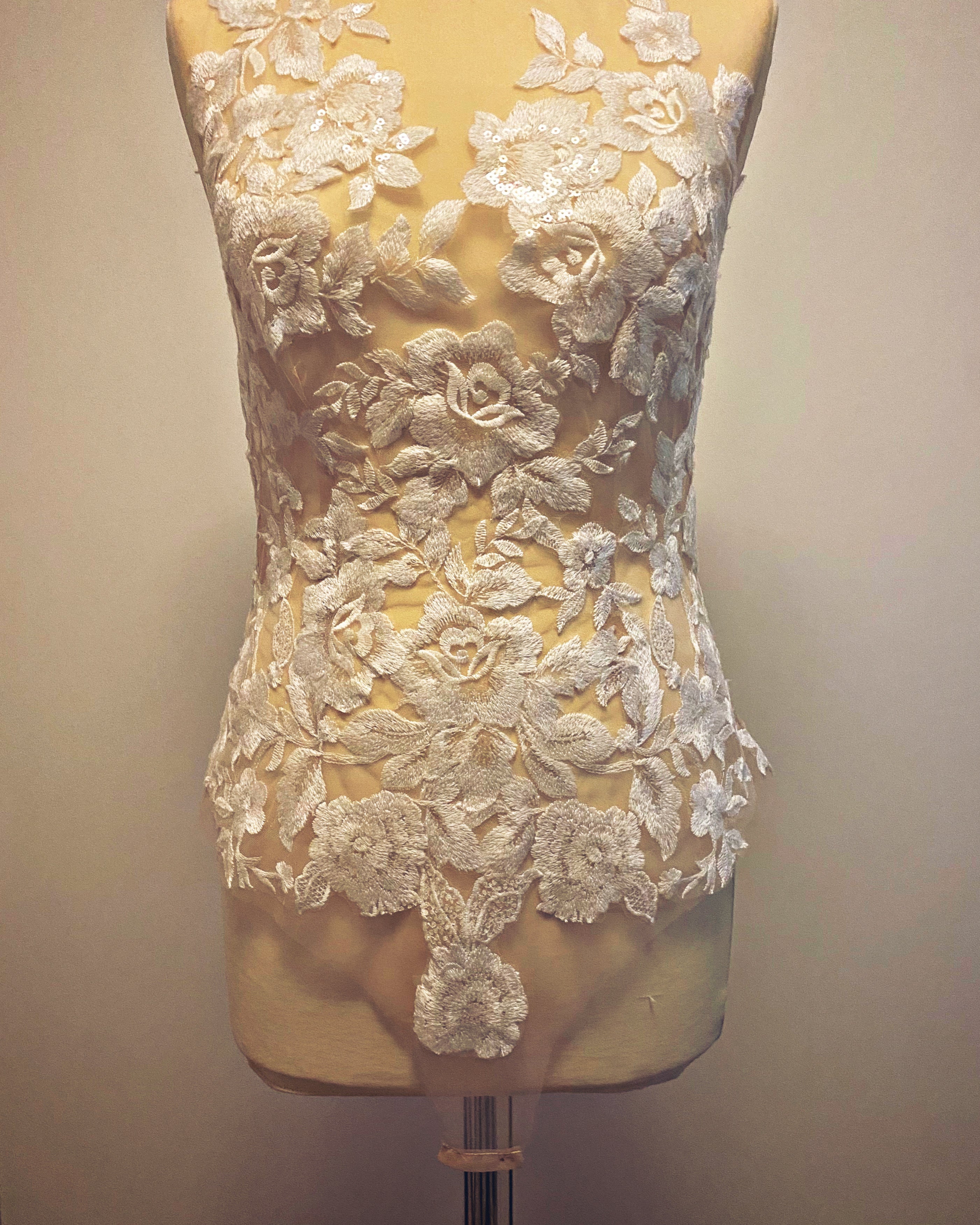 Mythic Nymph bridal bodysuit top by PETRA KARA, featuring delicate lace and elegant floral details on a white sheer fabric.