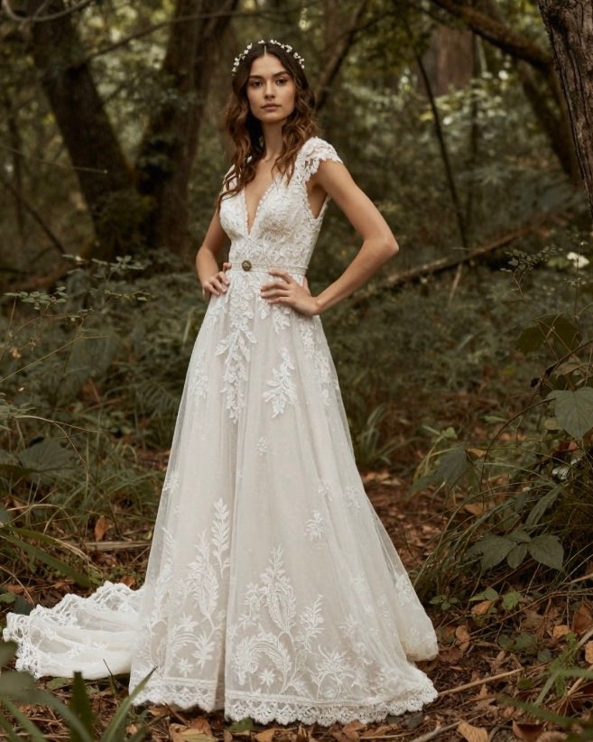 Elegant fairytale boho wedding dress by PETRA KARA featuring flowing fabric and intricate lace details.