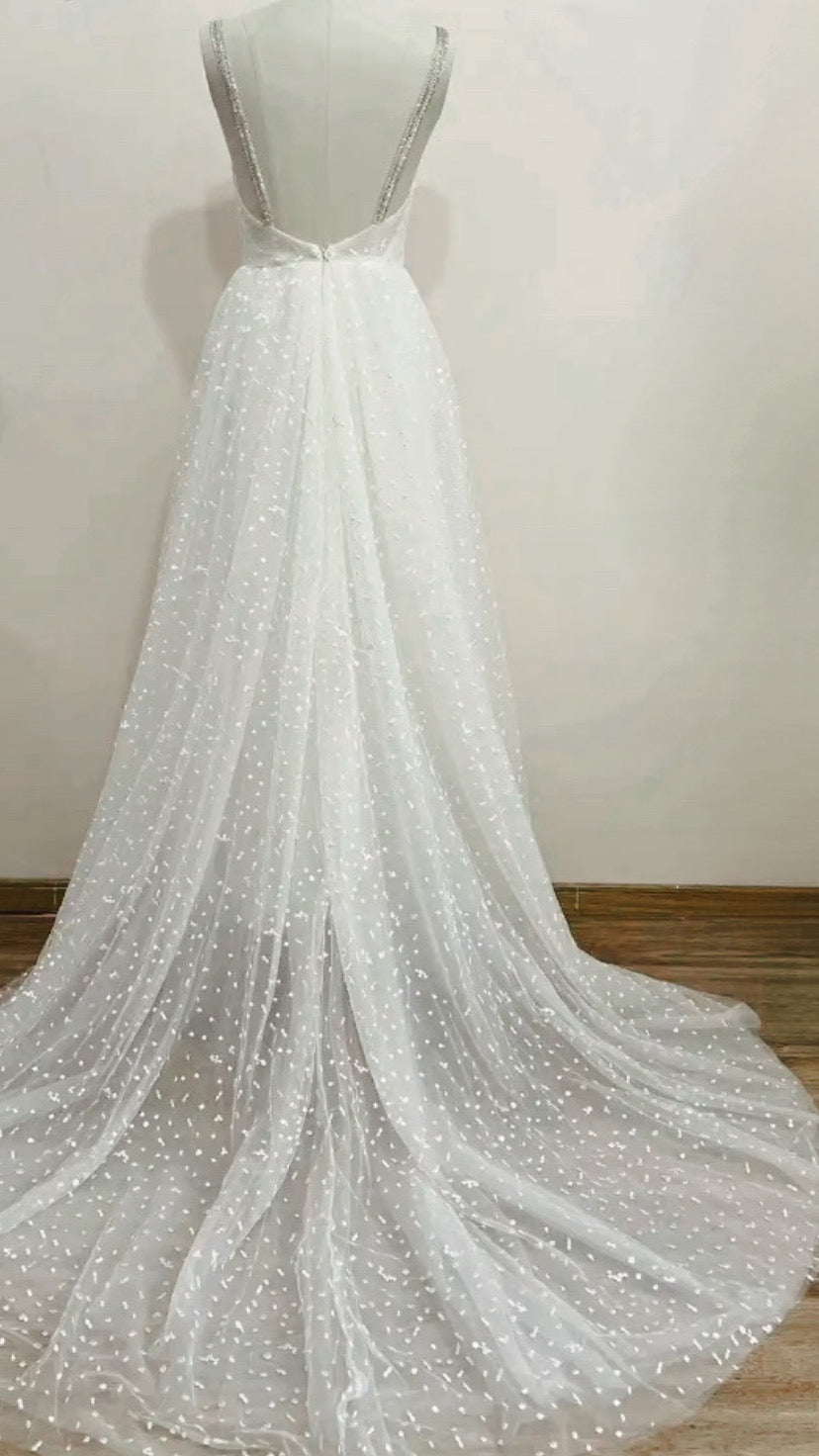 Boho wedding dress from STARS collection by Atelier Calliste, featuring flowing fabric and intricate details.