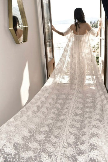 Ofelia wedding cape by Atelier Calliste featuring elegant lace and flowing fabric, available in sizes S to XXXL.