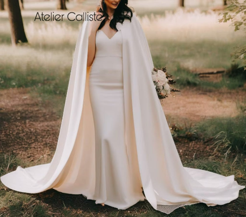 Minimal black cape from Atelier Calliste in size S to XXXL, shown draped on a mannequin, highlighting its sleek design and flowing fabric.