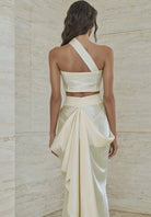 Atelier Calliste Ieria asymmetrical dress with flowing fabric and unique hemline, displayed on a mannequin.