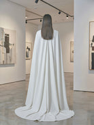 Minimalist beige cape from Atelier Calliste in size S to XXXL, featuring clean lines and soft fabric for elegant layering.