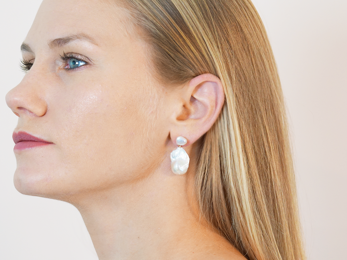 PM Atelier Adelaide Baroque Pearl Earrings featuring elegant, irregular-shaped pearls with silver hooks on a white background.