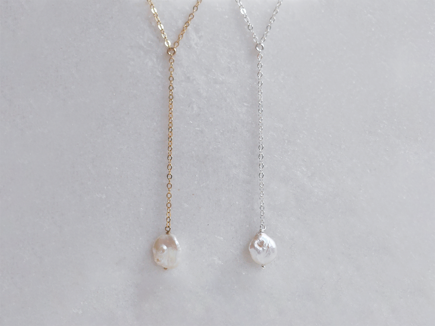 Alyssa lariat necklace with Keishi pearl by PM Atelier, featuring elegant pearl details perfect for brides, shown on a display.