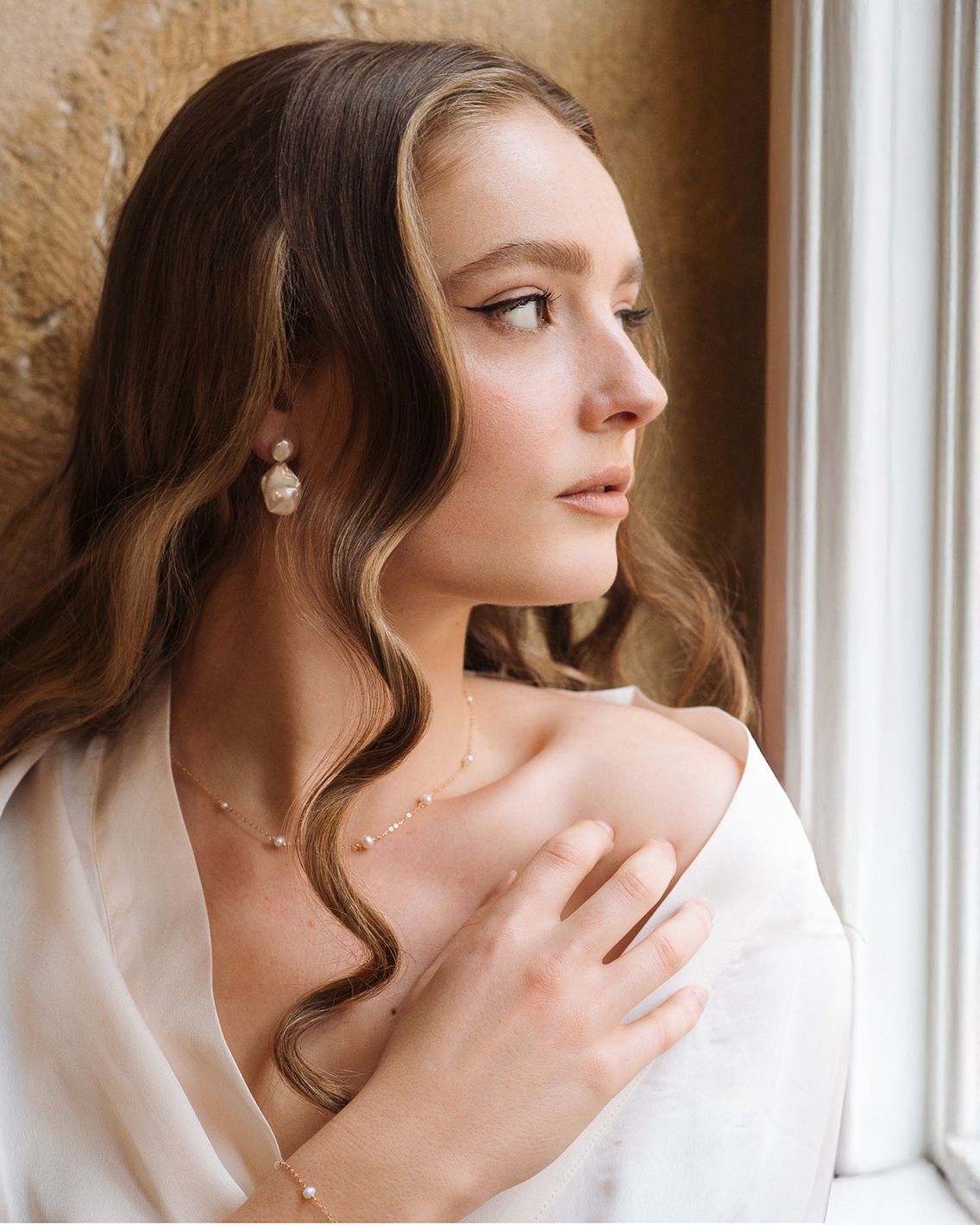 Dainty pearl earrings with gold accents from PM Atelier's Adelaide Baroque Pearl Earrings collection.